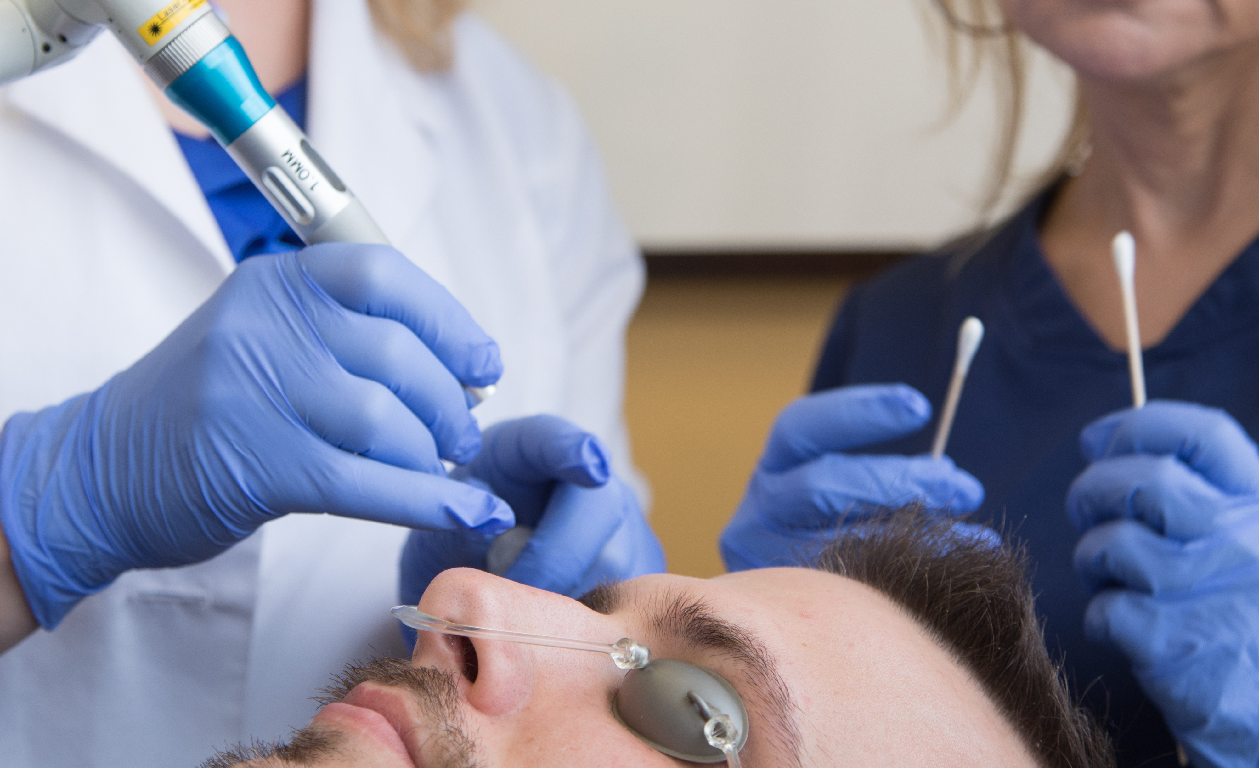 Doctor performing a laser treatment on a male patient